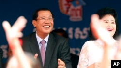 Cambodian Prime Minister and President of Cambodian People's Party Hun Sen, left, and his wife Bun Rany attend an event by his ruling party to mark the 37th anniversary of the 1979 downfall of the Khmer Rouge regime at the party headquarters in Phnom Penh, Cambodia, Thursday, Jan. 7, 2016. (AP Photo/Heng Sinith)