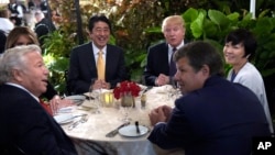 Presiden AS Donald Trump dan Perdana Menteri Jepang Shinzo Abe beserta istri masing-masing serta pejabat terkait di Mar-a-Lago di Palm Beach, Florida (10/2). (AP/Susan Walsh)
