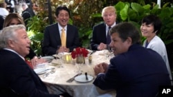 President Donald Trump, third from right, and first lady Melania Trump, hidden at left, sit down to dinner with Japanese Prime Minister Shinzo Abe, third from left, and his wife Akie Abe, right, at Mar-a-Lago in Palm Beach, Florida, Feb. 10, 2017.