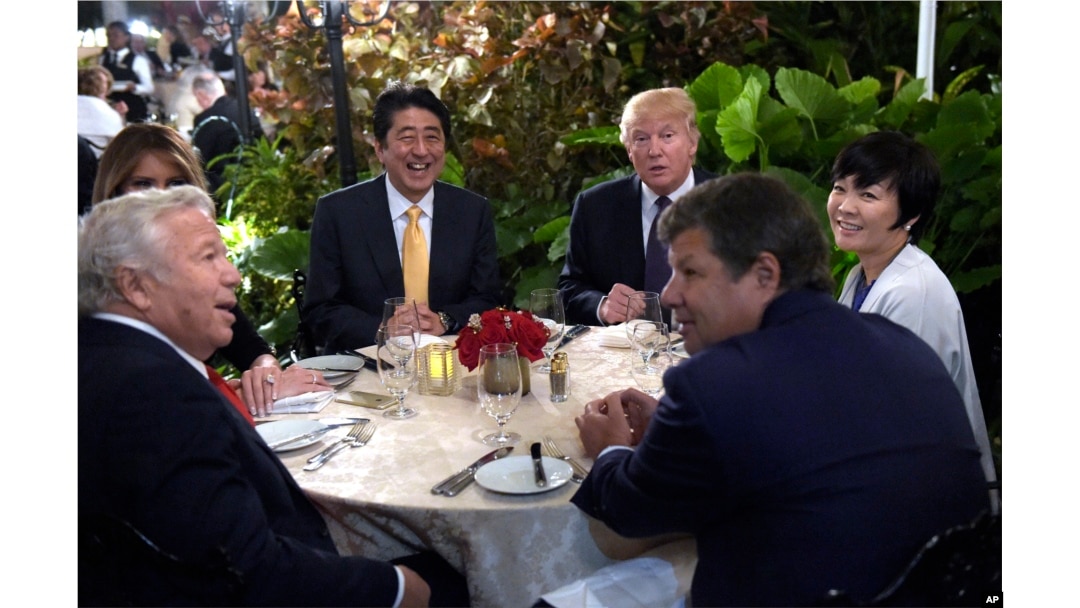 President Donald Trump, third from right, and first lady Melania Trump, hidden at left, sit down to dinner with Japanese Prime Minister Shinzo Abe, third from left, and his wife Akie Abe, right, at Mar-a-Lago in Palm Beach, Florida, Feb. 10, 2017.
