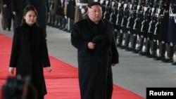 North Korean leader Kim Jong Un and wife Ri Sol Ju inspect an honour guard before leaving Pyongyang for a visit to China, this Jan. 7, 2019 photo released by North Korea's Korean Central News Agency (KCNA) in Pyongyang, Jan. 8, 2019.