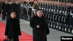 North Korean leader Kim Jong Un and wife Ri Sol Ju inspect an honour guard before leaving Pyongyang for a visit to China, this Jan. 7, 2019 photo released by North Korea's Korean Central News Agency (KCNA) in Pyongyang, Jan. 8, 2019. 