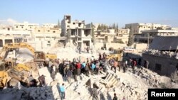 Warga mencari para korban yang selamat di antara reruntuhan bangunan yang hancur akibat serangan misil Scud di wilayah Hretan, timur laut kota Aleppo, Suriah (29/3).