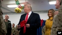 Presiden AS Donald Trump dan ibu negara Melania Trump saat mengunjungi pasukan AS di pangkalan udara Al Asad, Irak , Rabu (26/12). 