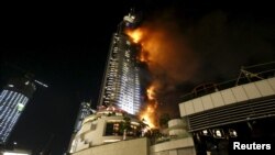 Hotel Address yang terletak di seberang gedung pencakar langit tertinggi di dunia, Burj Khalifa, di Dubai, UEA, terbakar hari Kamis (31/12) malam.