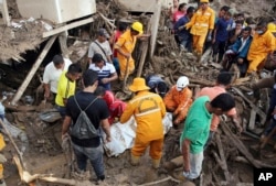 Firefighters and rescuers cover with a blanket the body of a woman in Mocoa, Colombia, April 2, 2017.