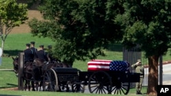 Una cureña tirada por caballos lleva el ataúd del senador John McCain a su tumba en el Cementerio de la Academia Naval de EE.UU. en Annapolis, Maryland, el domingo, 2 de septiembre de 2018.