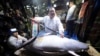 Kiyoshi Kimura, center, president of Kiyomura Co., poses with the bluefin tuna he bought at the annual New Year auction, at his Sushi Zanmai restaurant near Tsukiji fish market in Tokyo, Jan. 5, 2018. This year's top per kilogram price, for a smaller tuna
