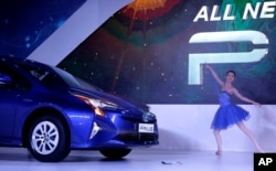 A performer dances as Toyota's 4th generation Prius Hybrid car is launched at the Auto Expo in Greater Noida, near New Delhi, India, Feb. 4, 2016.