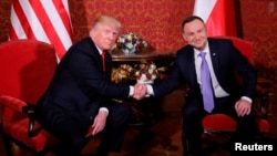 U.S. President Donald Trump is greeted by Polish President Andrzej Duda as he visits Poland during the Three Seas Initiative Summit in Warsaw, July 6, 2017.