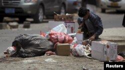 A boy searches for food amongst litter in Sanaa, April 8, 2015.