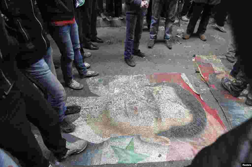 Demonstrators step on a picture of Syria's President Bashar al-Assad during a protest against his regime in Aleppo's Bustan al-Qasr district, January 4, 2013.