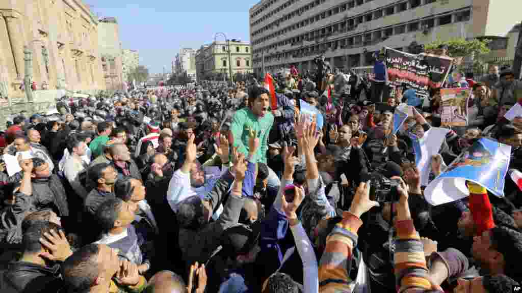 'Yan Sanda da mutane sun yi cincirindo a gaban ofishin da aka lalata bayan da bom ya fashe a cikin birnin Al-kahira, Junairu 24, 2014.