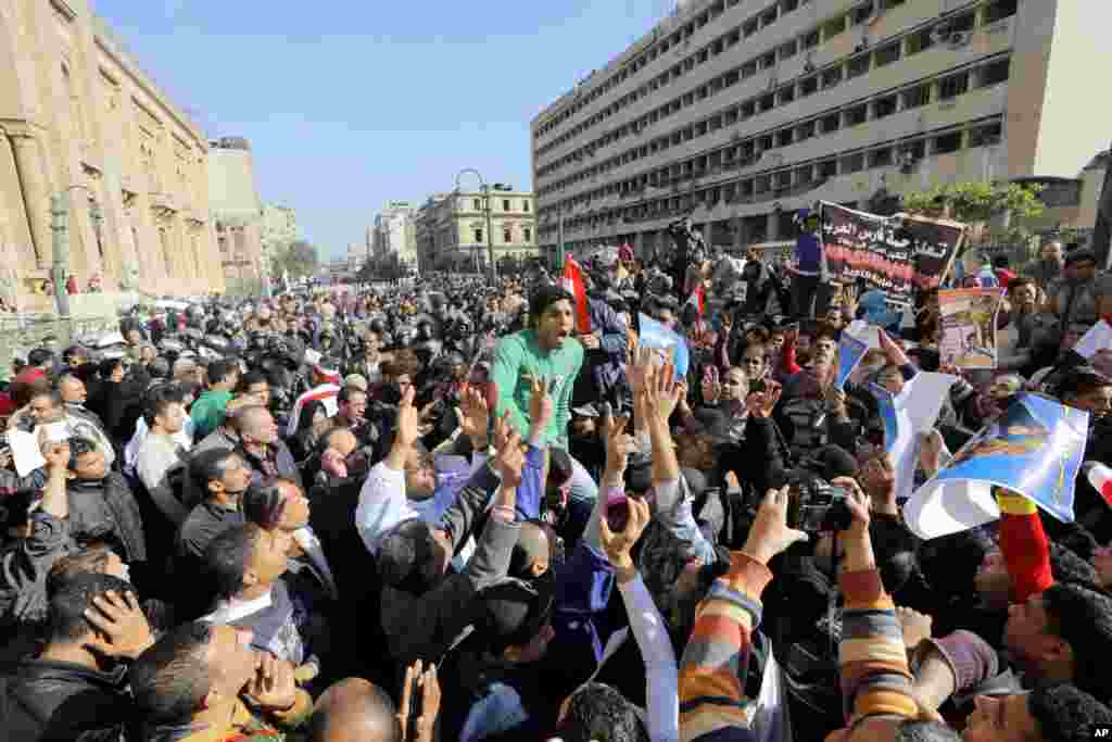 Manifestantes gritam palavras de ordem contra o terrorismo na rua principal da sede da polícia egípcia, no Cairo, Jan. 24, 2014.