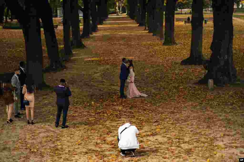 A couple wearing wedding outfits pose for photos at Cinquantenaire park in an autumn day in Brussels, Friday, Oct. 23, 2020. Belgian Prime Minister Alexander De Croo stopped short Friday of imposing another full lockdown, as the country did in March, but