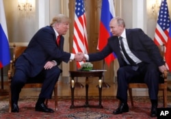 El presidente de EE.UU., Donald Trump y el presidente ruso Vladimir Putin, se saludan al inicio de una reunión en Helsinki, Finlandia, el 16 de julio de 2018.