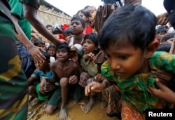 FILE - Rohingya refugee children struggle as they wait to receive food outside the distribution center at Palong Khali refugee camp near Cox's Bazar, Bangladesh, Nov. 17, 2017.