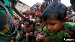 FILE - Rohingya refugee children struggle as they wait to receive food outside the distribution center at Palong Khali refugee camp near Cox's Bazar, Bangladesh, Nov. 17, 2017. 