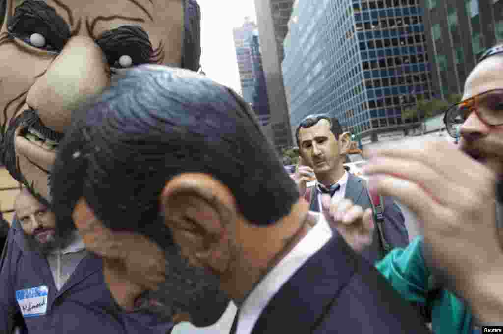 ພວກປະທ້ວງ ທີ່ນຸ່ງເຄື່ອງເປັນທ່ານ Mahmoud Ahmadinejad ປະທານາທິບໍດີອິຣ່ານ ກັບທ່ານ Bashar al-Assad ປະທານາທິບໍດີຊີເຣຍ ທໍາການປະທ້ວງ ຢູ່ນອກສໍານັກງານໃຫຍ່ຂອງອົງການສະຫະປະຊາຊາດ ທີ່ນະຄອນນິວຢອກ, ວັນທີ 26 ກັນຍາ 2012. 