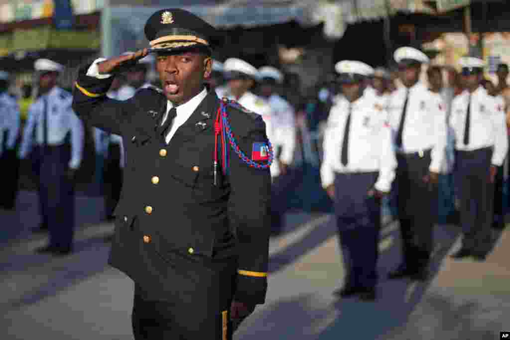 National police officer Shatner Jean salutes during a ceremony marking the 208th anniversary of the assassination of Haiti's independence hero and founding father Jean-Jacques Dessalines, in Port-au-Prince, Haiti.