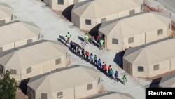 부모와 함께 미국과 멕시코 국경을 통해 미국으로 밀입국하다 적발된 어린이들이 19일 텍사스주 토닐로에서 부모와 격리된 채 미성년자 격리시설로 들어가고 있다. 