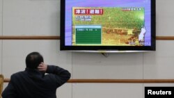 Un hombre lee sobre la alerta de tsunami tras un fuerte terremoto en el norte de Japón. La alerta fue levantada horas después.