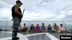 FILE - An Indonesian soldier stands guard near detained Vietnamese fisherman onboard Indonesian warship, KRI Barakuda 633, off the Natuna Sea in Anambas, Kepulauan Riau province, Dec. 5, 2014.