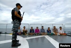 An Indonesian soldier stands guard near detained Vietnamese fisherman onboard Indonesian warship, KRI Barakuda 633, off the Natuna sea in Anambas, Kepulauan Riau province