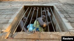 Des prisonnières assises à la fenêtre de leur cellule dans la prison de la rivière Yei dans le sud du Soudan, 15 avril 2006.