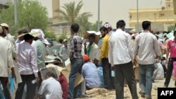 FILE - Foreign illegal laborers wait in a queue at the Saudi immigration offices at al-Isha quarter in al-Khazan district west of Riyadh, June 30, 2013.