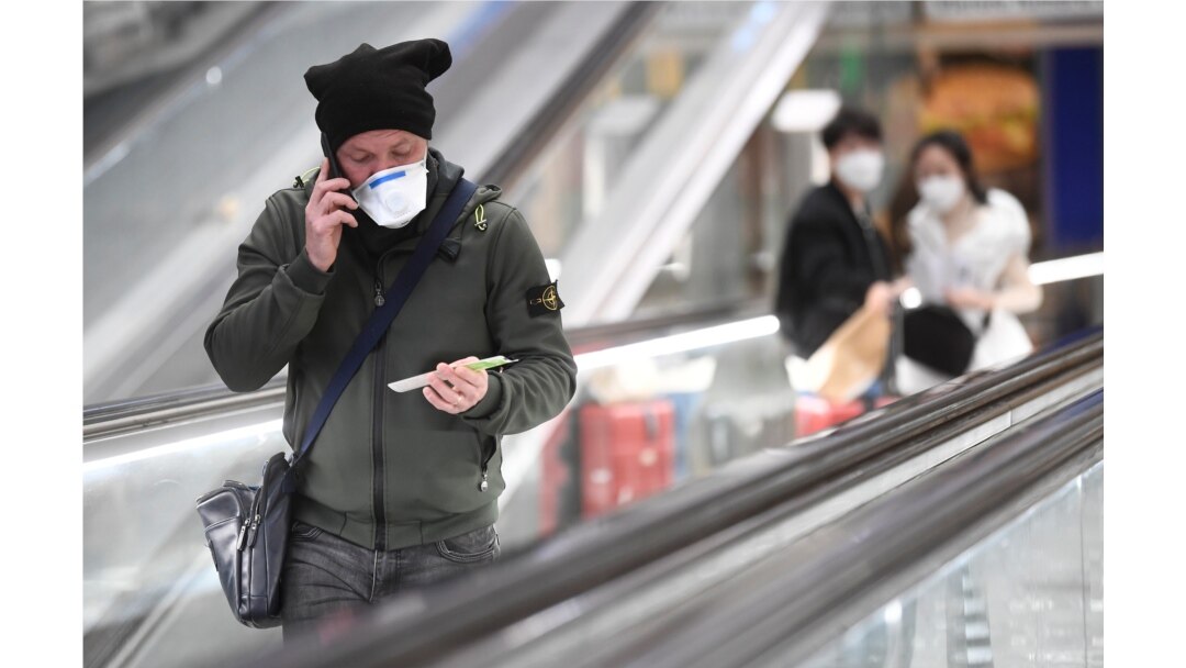 People wearing face masks are seen at the central railway station, after a coronavirus outbreak, in Milan, Italy February 24, 2020. REUTERS/Flavio Lo Scalzo
