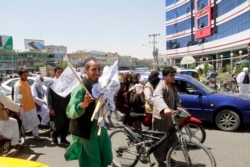 Seorang pria menjual bendera Taliban di jalanan, sementara kelompok militan itu dilaporkan telah mengambil alih kekuasaan di Afghanistan (foto: dok).