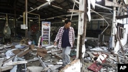 A man walks through rubles at the destroyed silk factory following the clash between Thailand and Cambodia in Surin province, northeastern Thailand, April 27, 2011