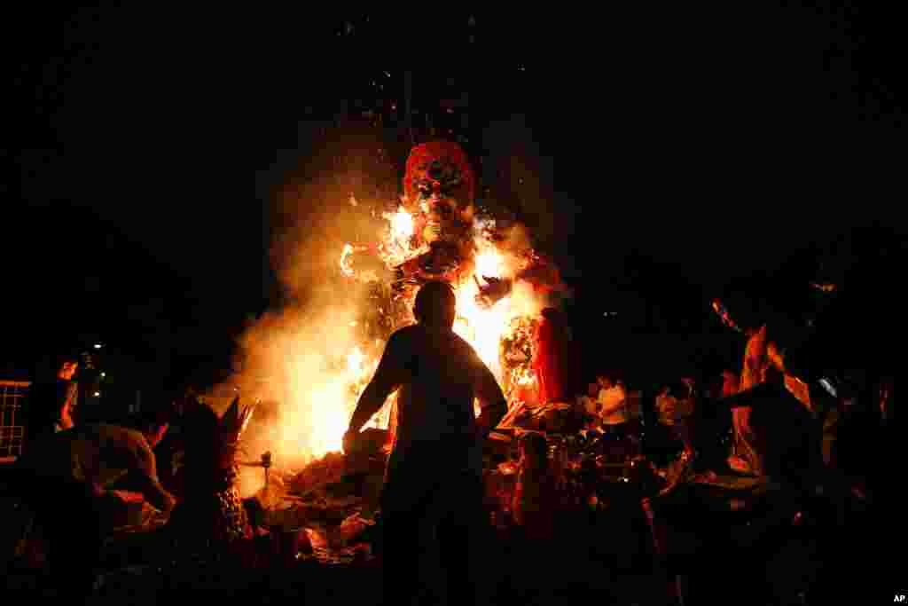 People burn a giant paper statue of the Chinese deity "Da Shi Ye" — or "Guardian God of Ghosts" — during the Chinese Hungry Ghost Festival in Kuala Lumpur, Malaysia.