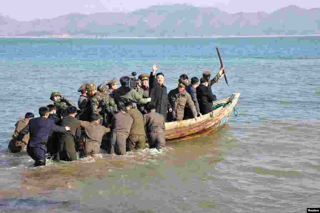 North Korean leader Kim Jong Un waves while in a boat during his visit to the Wolnae Islet Defence Detachment in the western sector of the front line, which is near Baengnyeong Island of South Korea March 11, 2013. (KCNA)