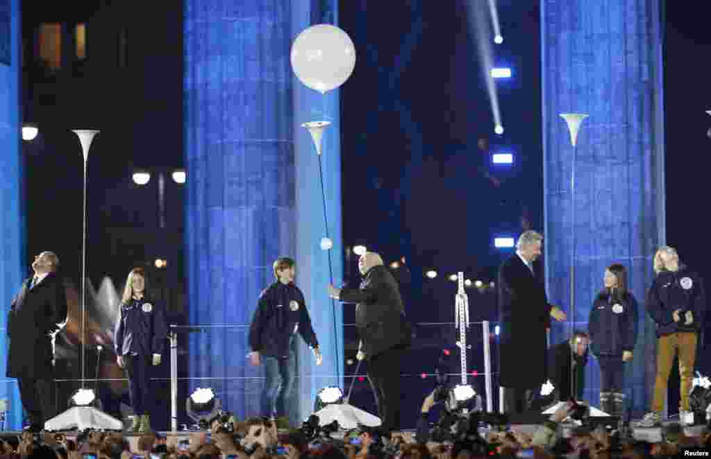 L&#39;ancien président soviétique Mikhaïl Gorbatchev, centre, lache un ballon à l&#39;installation &quot;Lichtgrenze&quot; (Frontière de la lumière) en face de la porte de Brandebourg à Berlin, le 9 novembre 2014. 