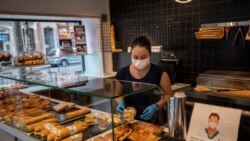 Una mujer con mascarilla prepara sandwiches en Barcelona el sábado 14 de marzo de 2020. El jefe de gobierno español anunció el sábado un estado de emergencia de dos semanas en un intento por contener el brote de un nuevo coronavirus.