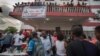 People mill around outside the APC headquarters in Sierra Leone. (O. Acland for VOA)