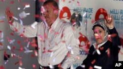 Turkish Prime Minister Recep Tayyip Erdogan and his wife Emine Erdogan wave to supporters after a rally in Ankara, Turkey, Friday, Aug. 8, 2014. 