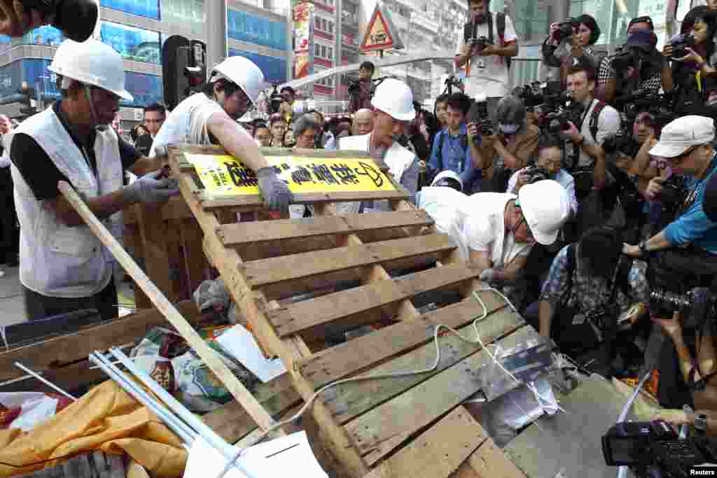 Workers demolish a barricade on one of the main streets under a court injunction at Mong Kok shopping district in Hong Kong, Nov. 25, 2014.