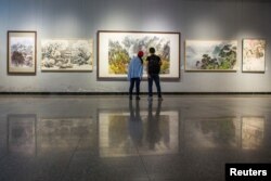 Visitors look at works by North Korean artists at the Mansudae Art Museum in the 798 art district in Beijing, China, September 20, 2017. (Reuters)