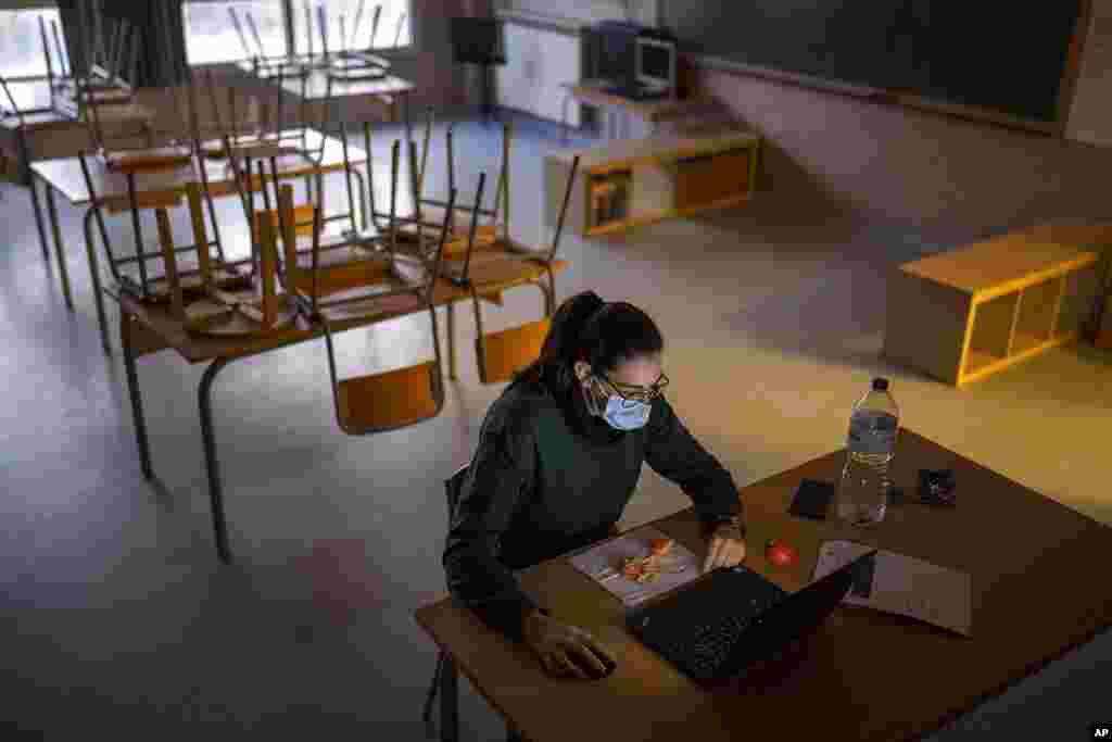 Interim elementary school teacher Marta Til works in her empty classroom after all 26 of her students were confined due to coronavirus infection, in a public school in Barcelona, Spain.