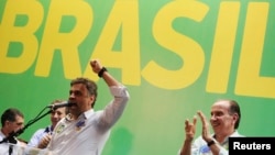Brazilian Social Democratic Party presidential candidate Aecio Neves talks to supporters next to his vice-presidential running mate Aloysio Nunes (R) during their campaign rally in Sao Paulo October 15, 2014.