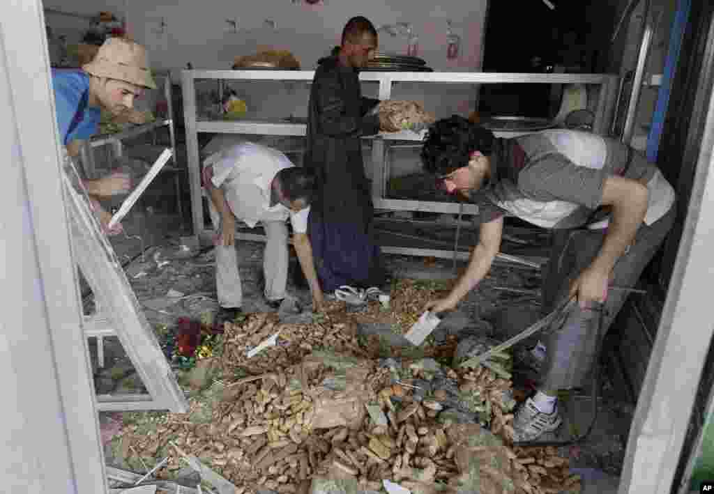 People clean up the aftermath of a car bomb attack at a bakery in the east Baghdad neighborhood of Kamaliya, Iraq, July 3, 2013.