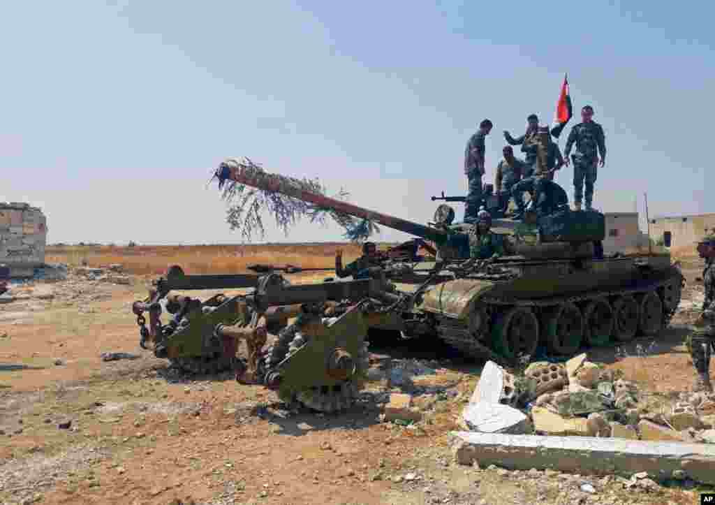 سربازان سوری سوار بر روی تانک در شمال غربی سوریه. ارتش اسد با حمایت روسیه بار دیگر به سمت محل استقرار مخالفان اسد می رود.&nbsp;