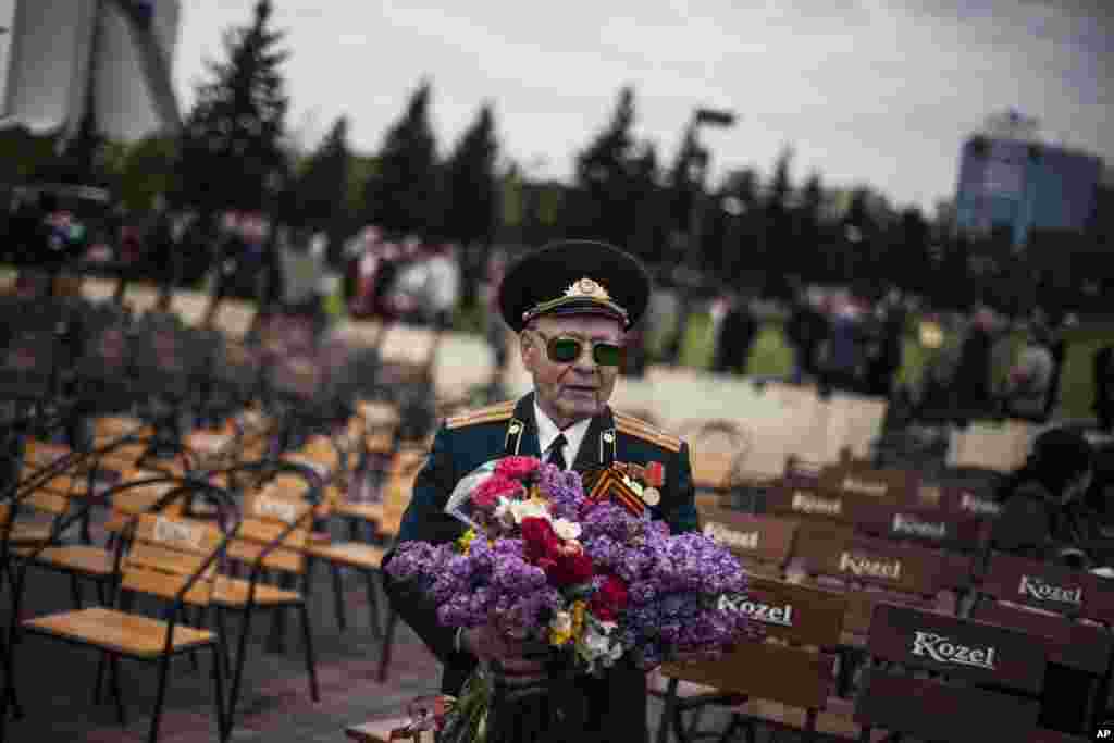 A veteran from the Red Army holds a bouquet of flowers while attending the commemoration of Victory Day in Donetsk, Ukraine, May 9, 2014.&nbsp;