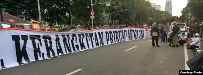 Spanduk putih berukuran besar bertuliskan "Pelantikan Anies-Sandi: Kebangkitan Pribumi Muslim".