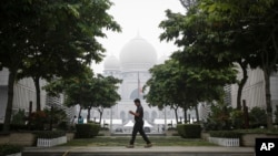 FILE - A Malaysian man walks past Palace of Justice shrouded in haze in Putrajaya, Malaysia, Sept. 11, 2015.