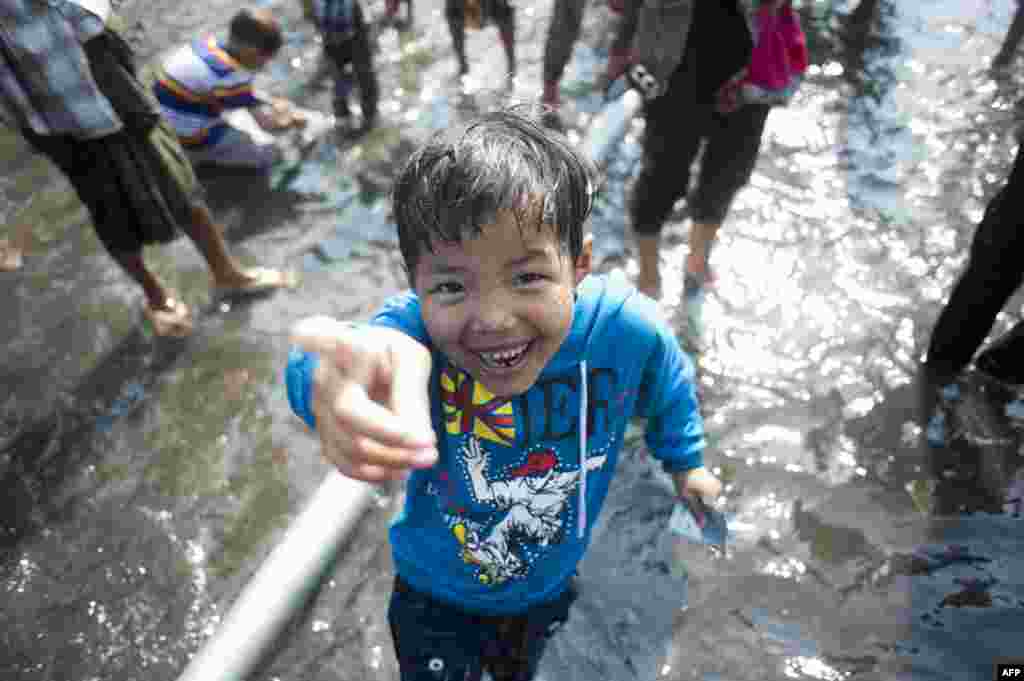 Seorang anak laki-laki berpartisipasi dalam perayaan Thingyan, festival air yang menandai tahun baru Myanmar di Rangoon, Myanmar, 13 April 2014.