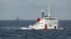 FILE - A Chinese Coast Guard vessel, with the disputed oil rig in the background, is seen in the South China Sea, June 2014.